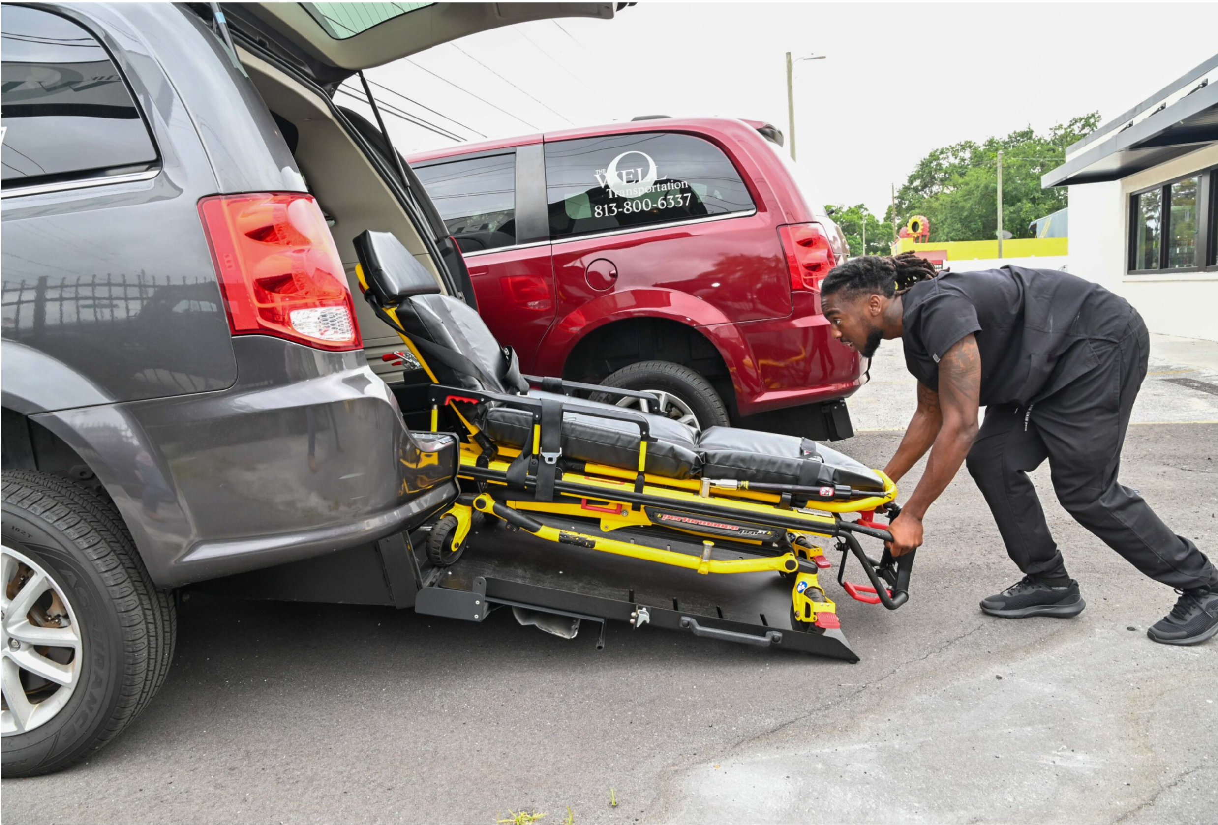 Well Transportation staff loading a Stryker stretcher into an accessible vehicle